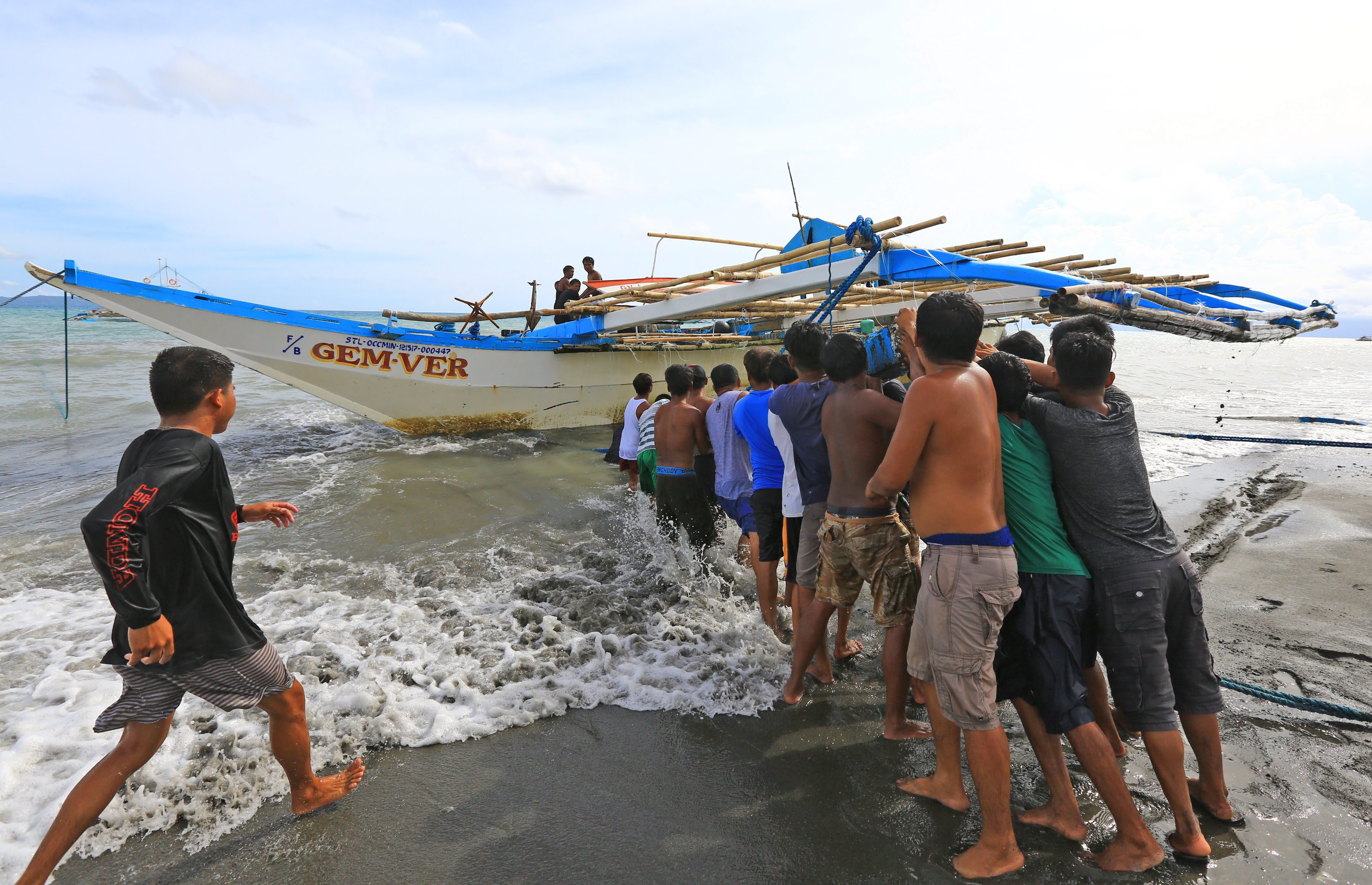 Fishermen pull the F/B Gem-Ver (or Gem-Vir) out of the water on June 15, 2019. Photo by Walter Bollozos, The Philippine STAR