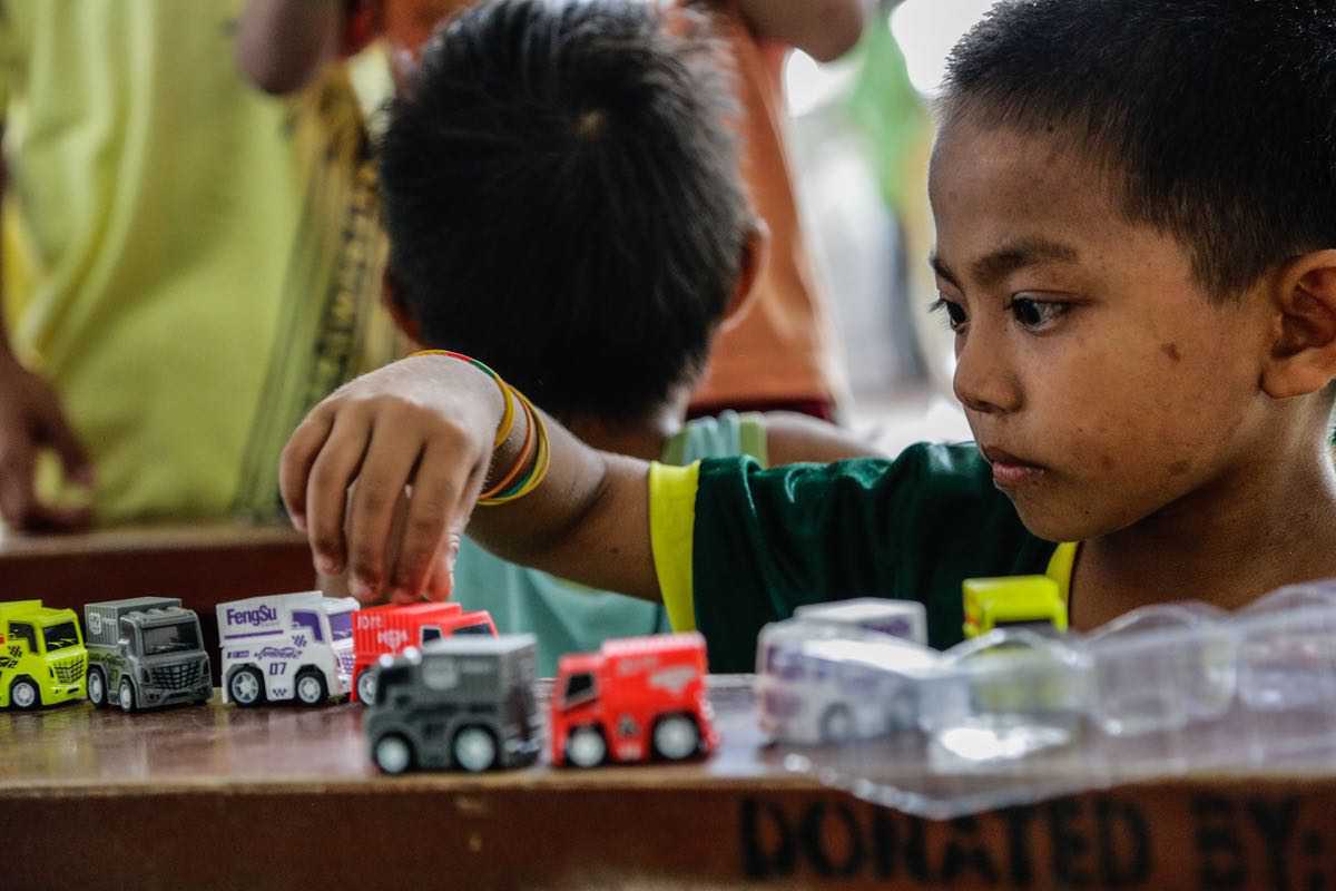 After the noise of Mount Taal’s eruption, this little boy spends some quiet time while playing with his new toy cars. After the noise of Mount Taal’s eruption, this little boy spends some quiet time while playing with his new toy cars.