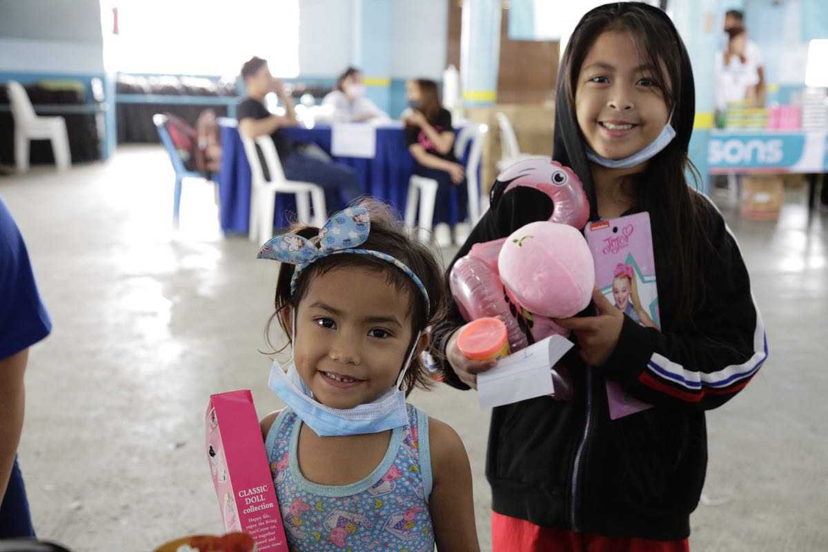 These little girls are all smiles as they receive their new toy packs from The SM Store. 
