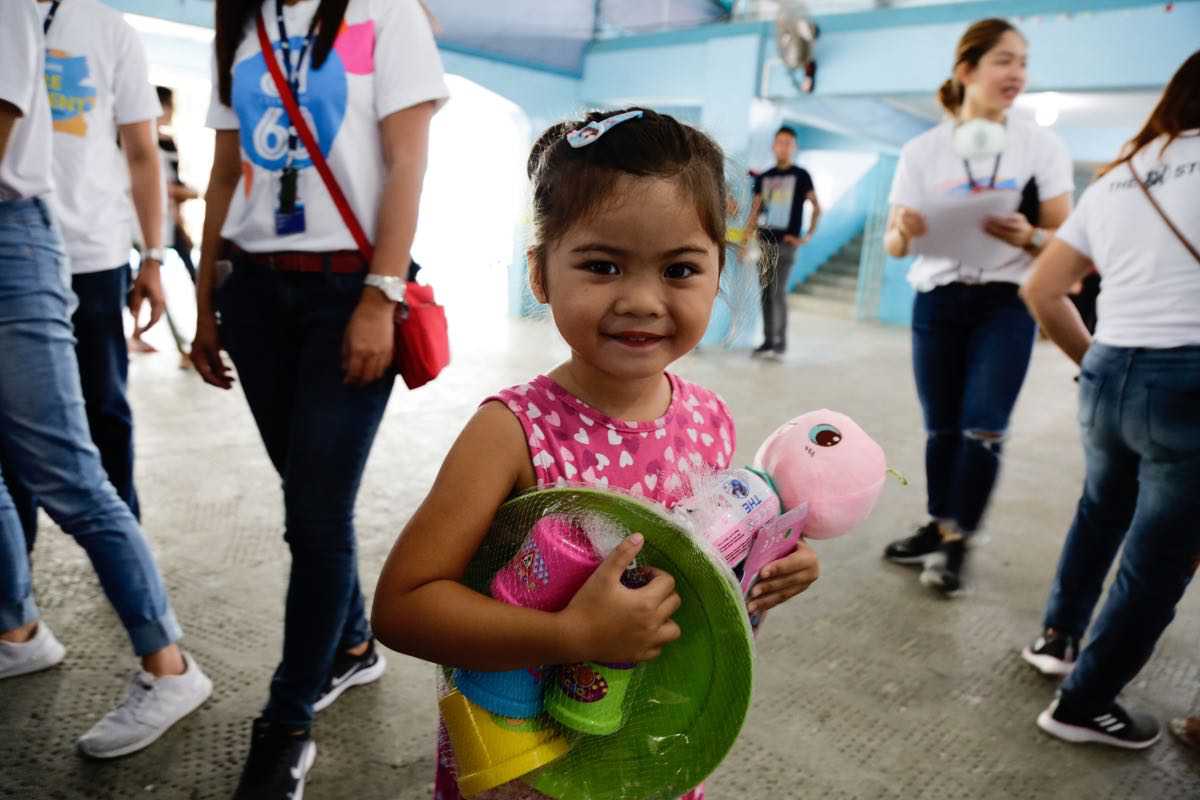 All smiles and ready to play, this little girl is excited with her new Play Doh sets and plush toy. All smiles and ready to play, this little girl is excited with her new Play Doh sets and plush toy.